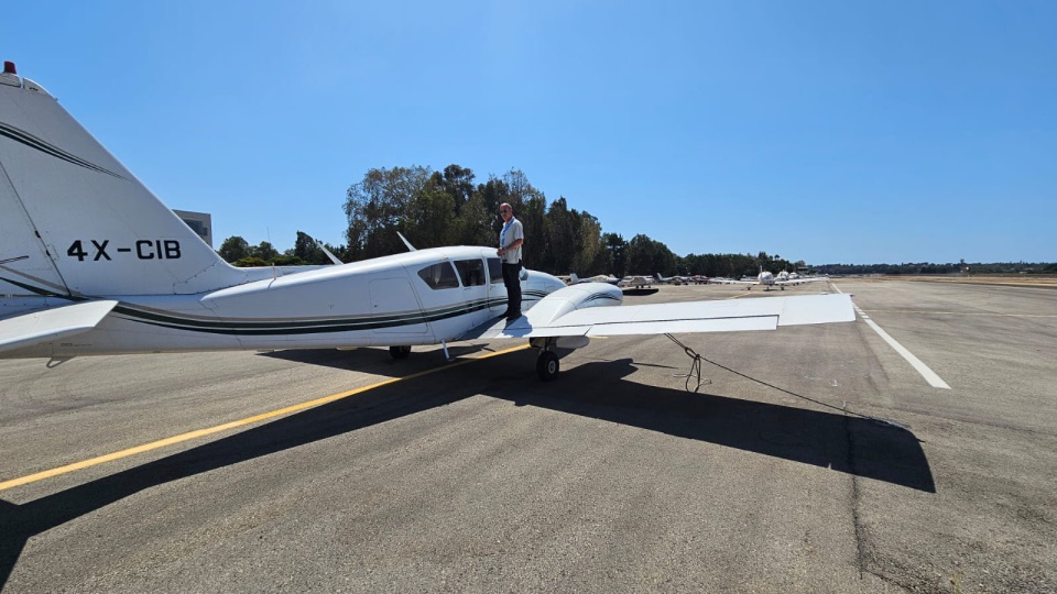 Pilot standing on the wing of 4X-CIB on the runway